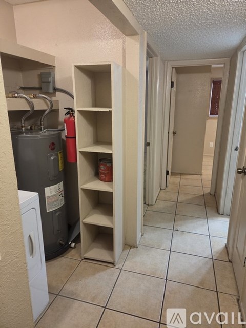 A hallway with a fire extinguisher in a cutout of a wall.