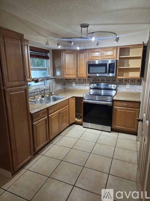 A kitchen with wooden cabinets and a black oven.