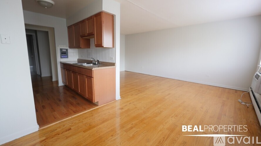 A kitchen with wooden floors and white walls is available for rent.
