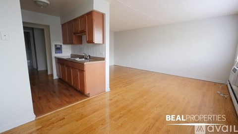A kitchen with wooden floors and white walls is available for rent.