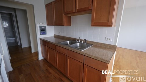 A kitchen with brown cabinets and a beige countertop.