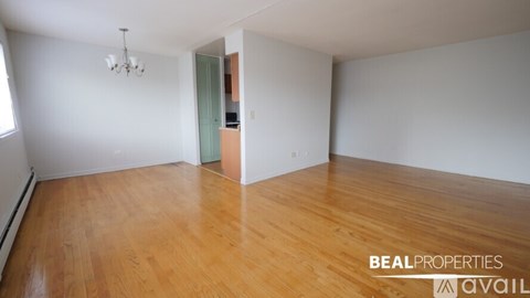 A room with wooden flooring and a chandelier is available for rent.