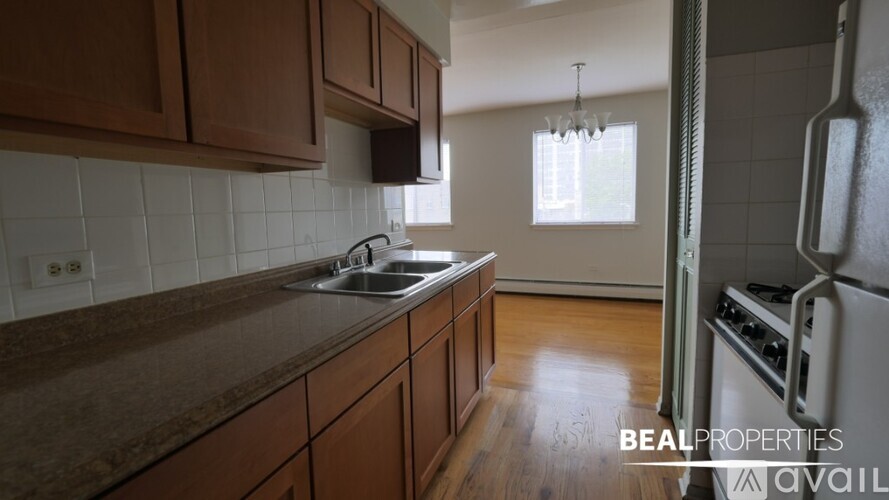 A kitchen with brown cabinets and a white sink.