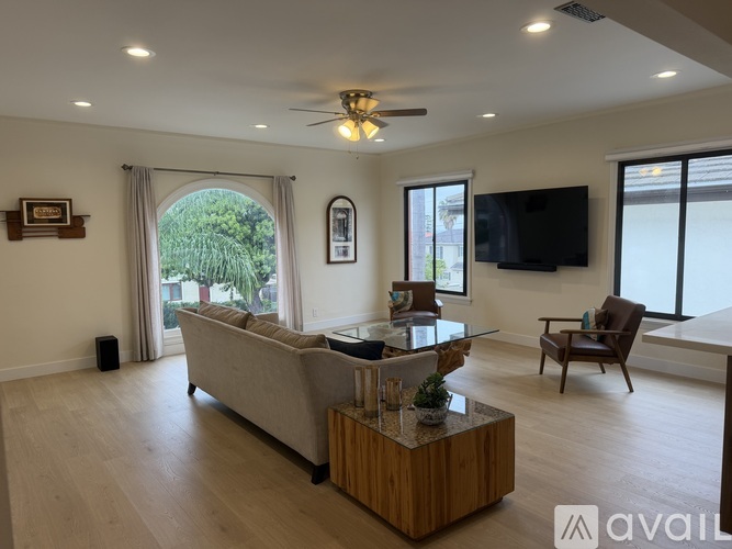 A living room with a couch, a chair, and a television.
