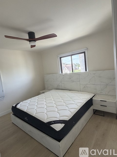 A bedroom with a large bed and a ceiling fan.