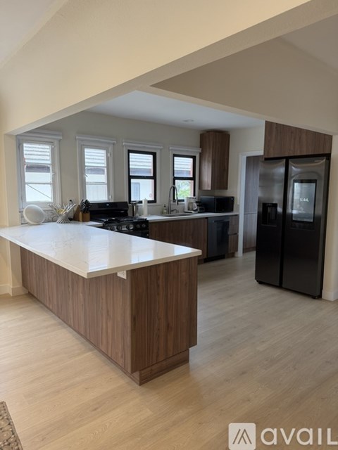 A kitchen with a white countertop and wooden cabinets.