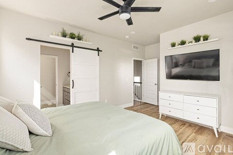 A bedroom with a bed, dresser, and a ceiling fan.