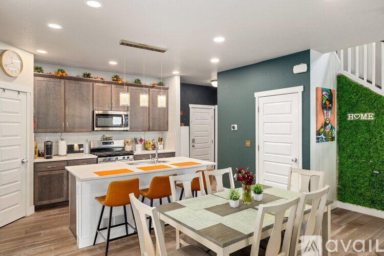 A kitchen with a dining table and chairs.