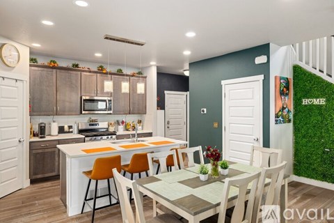 A kitchen with a dining table and chairs.