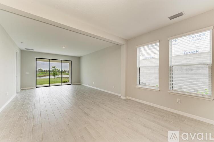 A spacious room with a sliding glass door leading to a balcony.