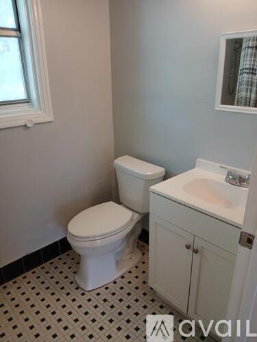 A white toilet and sink in a bathroom.