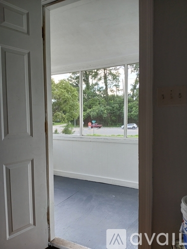 A room with a door and a window showing a view of the street.