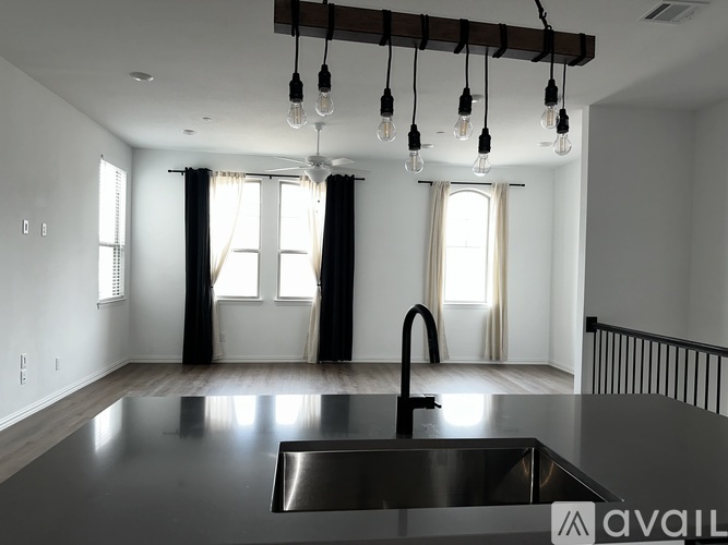 A modern kitchen with a black countertop and stainless steel sink.