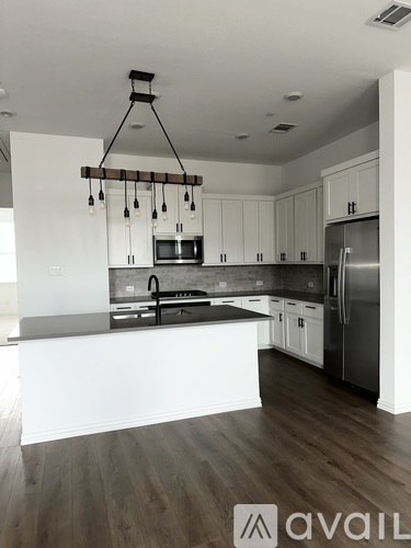 A modern kitchen with white cabinets and a wooden island.