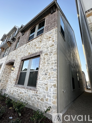 A stone building with a grey extension to the right.