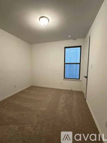 A room with a carpeted floor and a window.