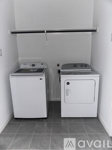 A white dryer and washing machine in a small room.