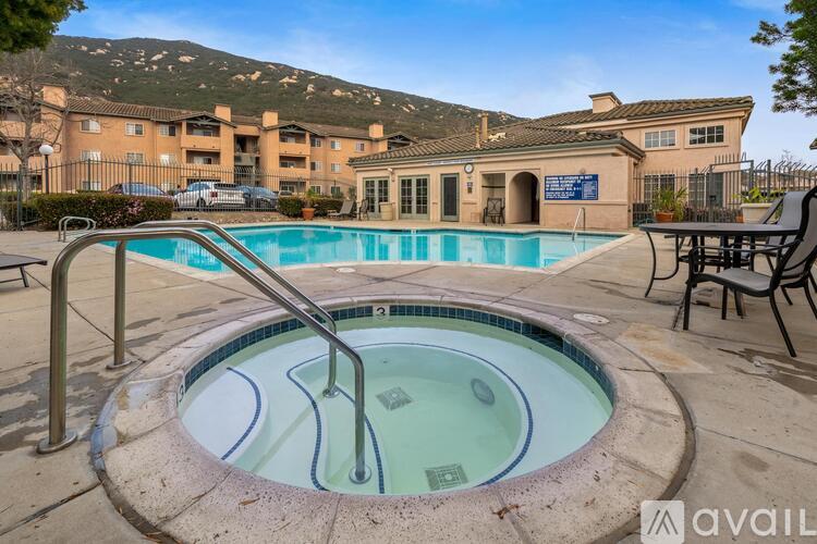 A hot tub sits in the middle of a pool area in front of a building.