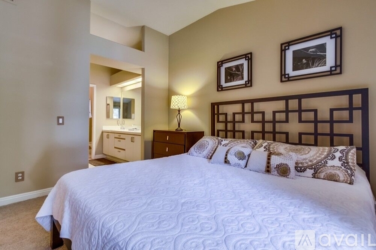 A bedroom with a large bed and a mirror.