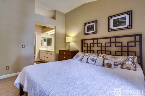 A bedroom with a large bed and a mirror.