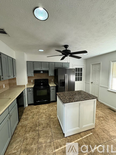 A kitchen with a black refrigerator and stove.
