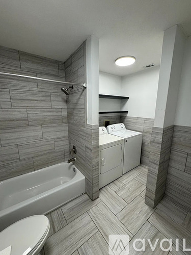A bathroom with a white tub and toilet.