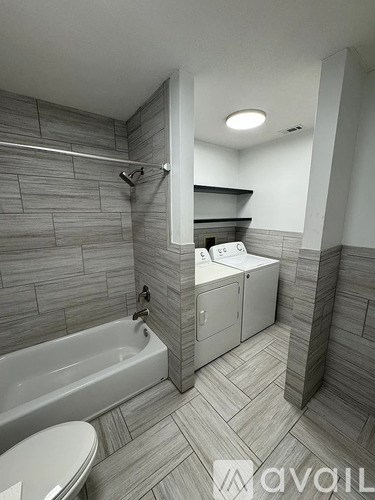 A bathroom with a white tub and toilet.