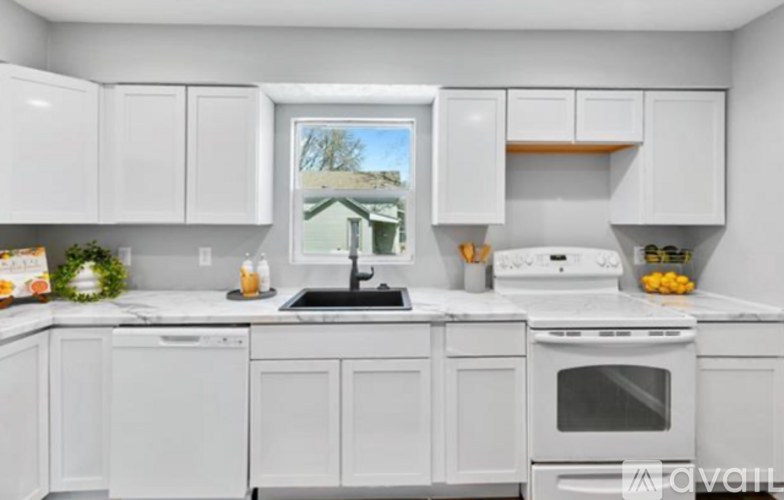 A kitchen with white cabinets and appliances.