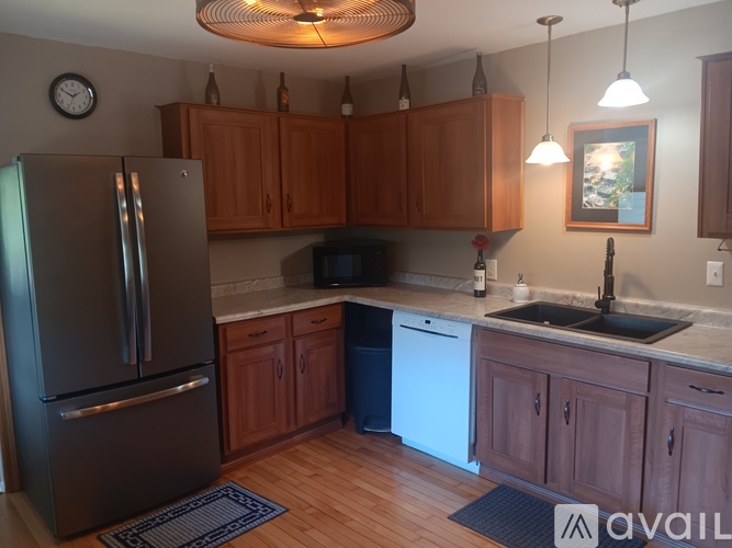 A kitchen with wooden cabinets and a black refrigerator.
