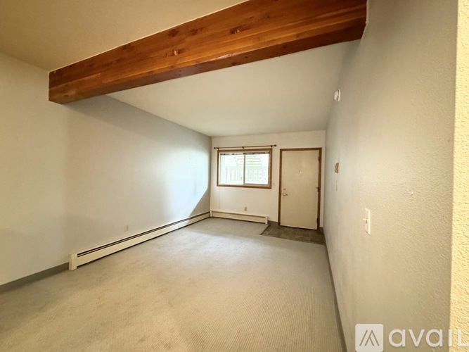 A room with a window and a door is available for rent.