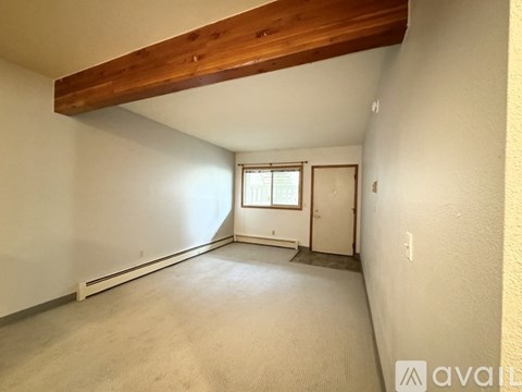 A room with a window and a door is available for rent.