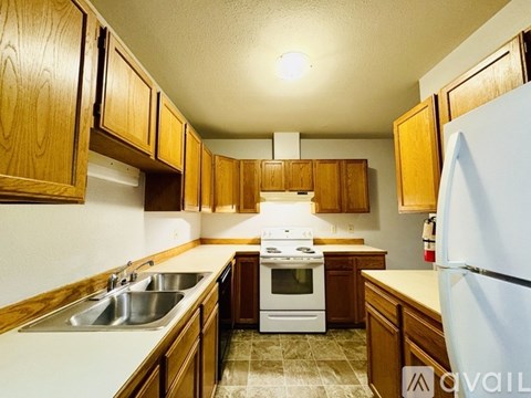 A kitchen with wooden cabinets and a white stove top oven.