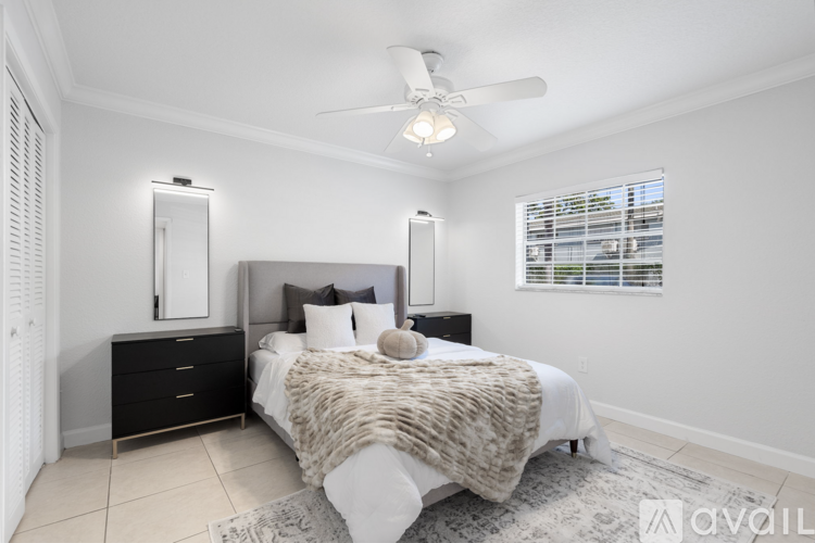 A bedroom with a large bed and a ceiling fan.