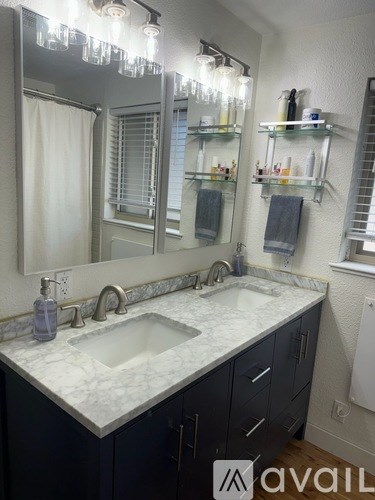 A bathroom with a marble countertop and a large mirror above the sink.