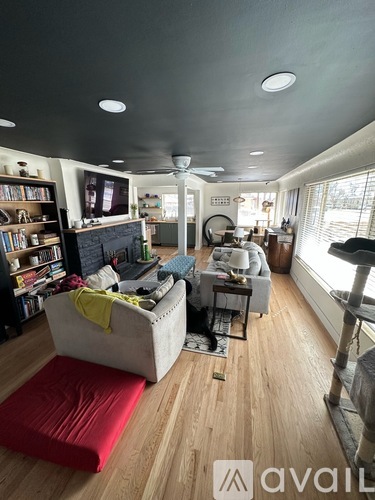 A living room with a white couch and a red rug.
