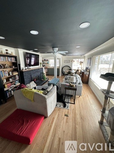 A living room with a white couch and a red rug.