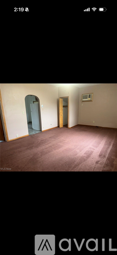 A room with a brown floor and a white door.