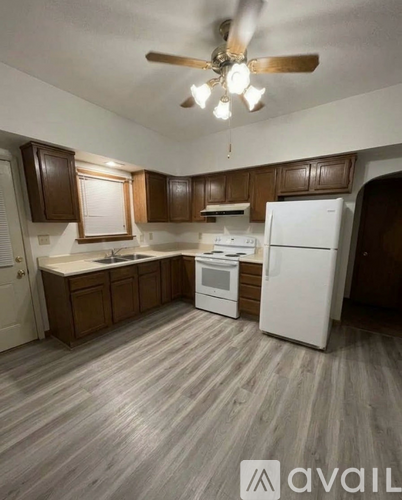 A kitchen with wooden cabinets and a white refrigerator.