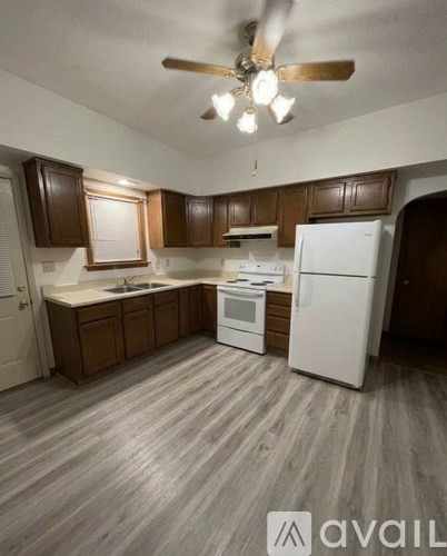 A kitchen with wooden cabinets and a white refrigerator.