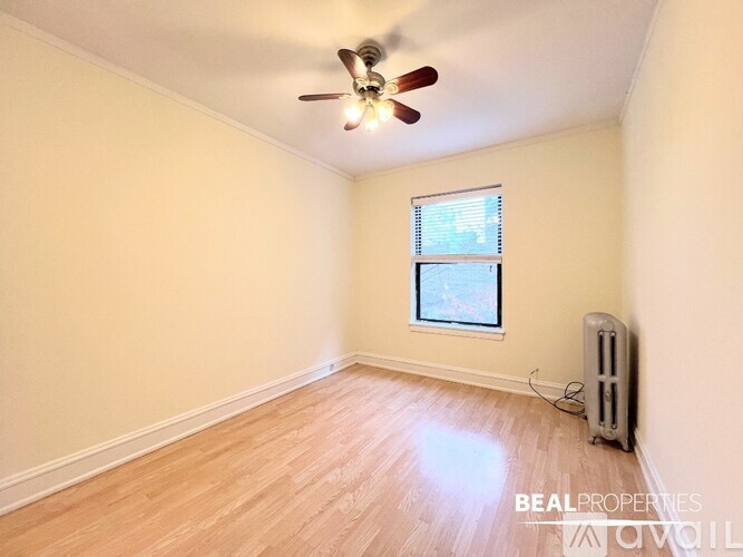 A room with a window and a fan on the ceiling.