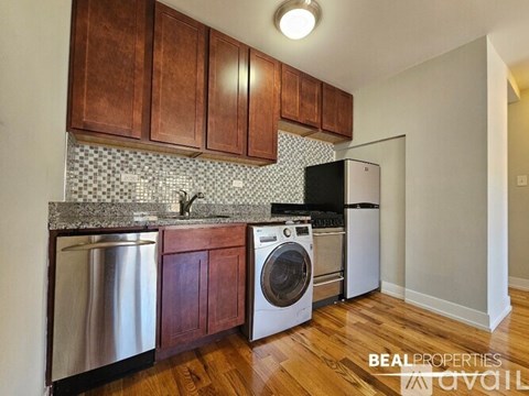 A kitchen with wooden cabinets and a black fridge.