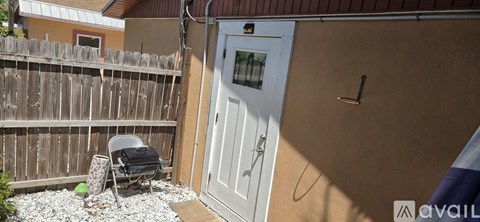 A white door is on the side of a tan building.