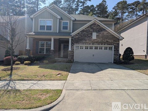 A house with a garage and a driveway in front.