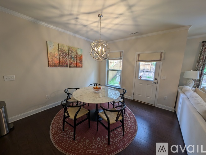 A dining room with a round table and chairs.
