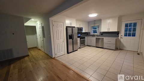 A kitchen with white cabinets and a refrigerator.