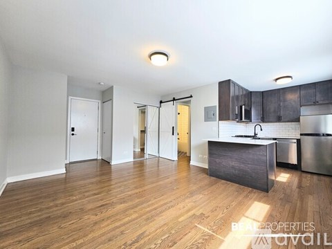 A kitchen area with a sink and a refrigerator.