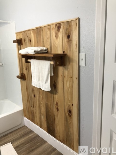 A wooden shelf with a white towel hanging on it.