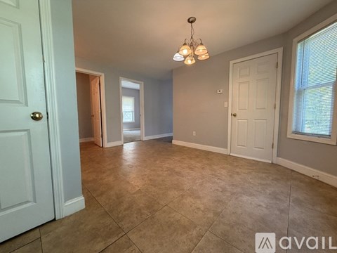 A room with a tiled floor and a chandelier hanging from the ceiling.