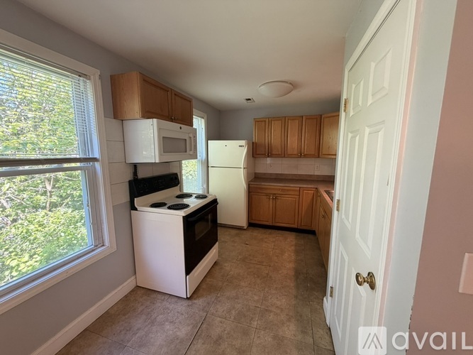 A kitchen with a white fridge and black stove top oven.