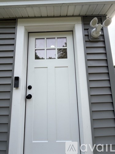 A white door with a black handle and a window above it.